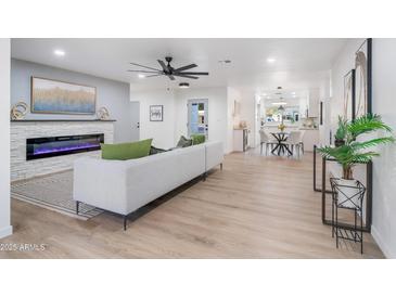 Bright living room with fireplace, hardwood floors, and open concept floor plan at 7749 E Coolidge St, Scottsdale, AZ 85251