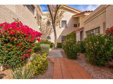 Attractive courtyard entry with red flowers and a brick pathway at 7800 E Lincoln Dr # 1096, Scottsdale, AZ 85250