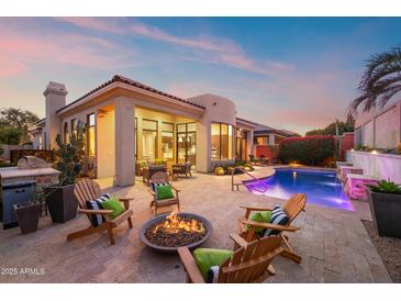 Luxury backyard oasis with a sparkling pool, fire pit, and comfortable seating at 8260 E Mohawk Ln, Scottsdale, AZ 85255