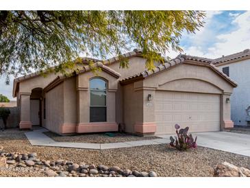 Beige house with a two-car garage and desert landscaping at 2625 N 110Th Dr, Avondale, AZ 85392