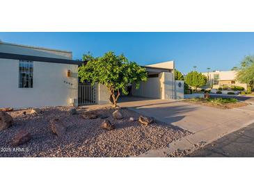 Mid-century modern home with carport and landscaped yard at 8642 E Monterosa Ave, Scottsdale, AZ 85251