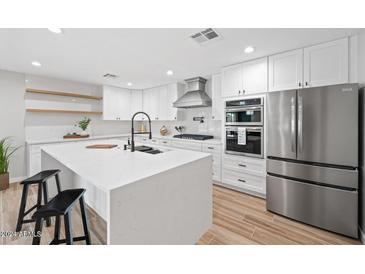 Modern kitchen with white cabinets, stainless steel appliances, and large island at 1010 E Indianola Ave, Phoenix, AZ 85014