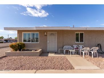 Tan single story home with small front patio and seating at 10518 W Oakmont Dr, Sun City, AZ 85351