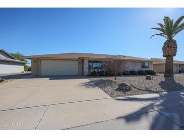 Brick ranch home with a two-car garage and mature landscaping at 12619 N Sun Valley Dr, Sun City, AZ 85351