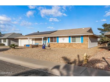 Ranch-style home with solar panels, landscaped yard, and blue accents at 12630 W Crystal Lake Dr, Sun City West, AZ 85375