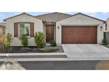 Single-story home with brown garage door and landscaping at 17855 W Thistle Landing Dr, Goodyear, AZ 85338