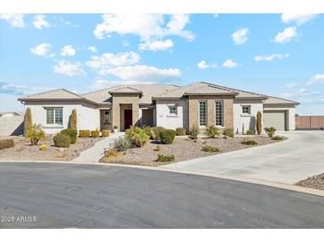 Single-story home with attractive landscaping and a long driveway at 216 W Paoli St, San Tan Valley, AZ 85143