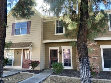 Tan two-story townhome with brick accents and landscaping at 3329 W Mcrae Way # 4, Phoenix, AZ 85027