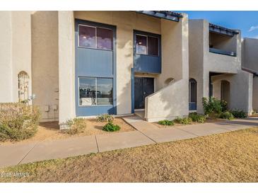 Tan two-story condo building with blue accents and a walkway at 8413 N 55Th Ave, Glendale, AZ 85302