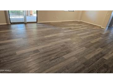 Living room with wood-look floors and access to patio at 955 E Knox Rd # 110, Chandler, AZ 85225