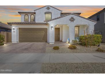Two-story house with brown garage door and landscaping at 14428 W Faye Way, Surprise, AZ 85387