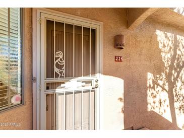Condo front door with security gate and Southwest design accents at 5450 E Mclellan Rd # 234, Mesa, AZ 85205