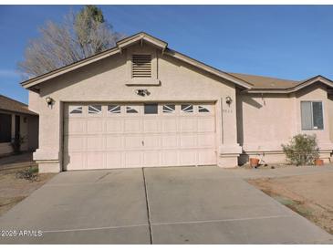 House exterior featuring a two-car garage and well-maintained landscaping at 7056 W Caron Dr, Peoria, AZ 85345