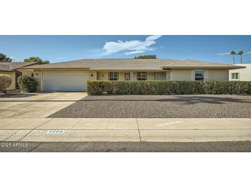 Single-story home with a well-maintained front yard and a spacious driveway at 9209 W Glen Oaks N Cir, Sun City, AZ 85351