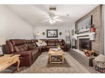 Cozy living room featuring a brown leather sectional sofa and a fireplace at 1018 W Ivanhoe St, Chandler, AZ 85224