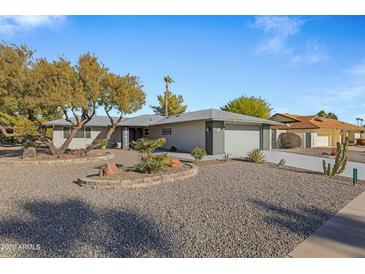 Single story home with gray exterior, landscaping, and a two-car garage at 12424 W Bluestem Dr, Sun City West, AZ 85375