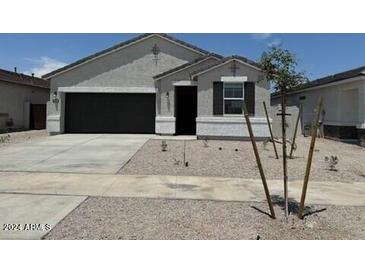 Single-story home with a two-car garage and desert landscaping at 15382 W Hackamore Dr, Surprise, AZ 85387