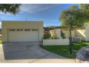 Single-story home with attached garage and well-manicured lawn at 6151 E Harvard St, Scottsdale, AZ 85257