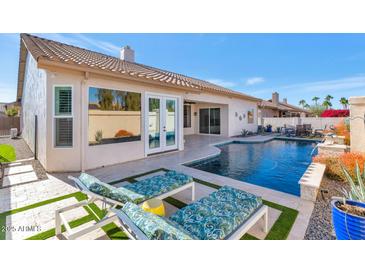 Inviting backyard oasis featuring a sparkling pool, lounge chairs, and lush landscaping at 8712 W Sequoia Dr, Peoria, AZ 85382