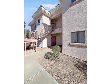 Exterior view of condo building with stairs and landscaping at 10030 W Indian School Rd # 101, Phoenix, AZ 85037