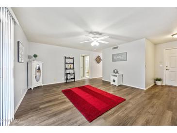 Bright living room with wood-look floors and a red rug at 10826 N 115Th Ave, Youngtown, AZ 85363