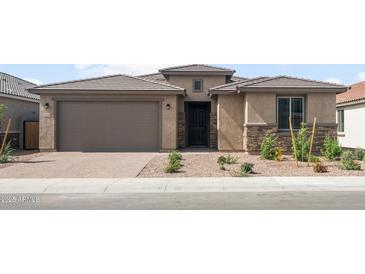 Inviting single story house featuring a covered entrance, garage, and manicured rock landscaping at 17638 W Rancho Dr, Litchfield Park, AZ 85340