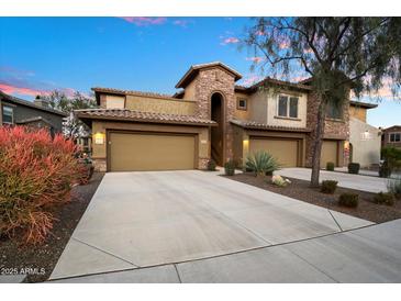 Tan two-story home with attached garage and desert landscaping at 2425 W Bronco Butte Trl # 2037, Phoenix, AZ 85085