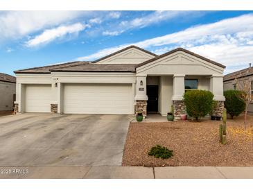 Single-story home with two-car garage, landscaping, and stone accents at 3224 N Lainey Ln, Buckeye, AZ 85396