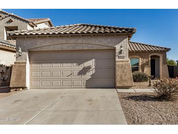 Tan house with tile roof, two-car garage, and desert landscaping at 42788 W Martie Lynn Rd, Maricopa, AZ 85138