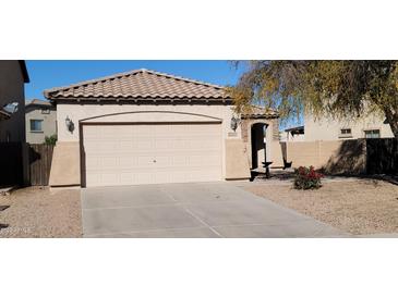 House exterior featuring a two-car garage and well-maintained landscaping at 42788 W Martie Lynn Rd, Maricopa, AZ 85138