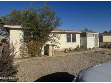 Ranch-style home with a gravel driveway and mature landscaping at 504 W Baseline Rd, Buckeye, AZ 85326