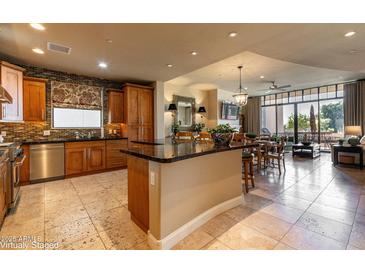 Open kitchen with granite island, stainless steel appliances, and custom cabinetry at 8 Biltmore Est # 123, Phoenix, AZ 85016