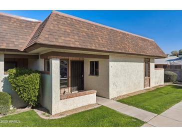 Inviting exterior of a condo with a well-maintained lawn and walkway at 8131 N 107Th Ave # 81, Peoria, AZ 85345