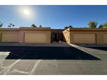 Front view of a tan colored complex, featuring multiple garages and a walkway at 1319 E Susan Ln, Tempe, AZ 85288