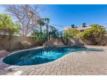 Inviting kidney-shaped pool with brick patio and lush landscaping at 1640 N Sawyer --, Mesa, AZ 85207