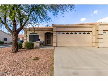 Tan stucco house with two-car garage and landscaped front yard at 2101 S Yellow Wood -- # 75, Mesa, AZ 85209