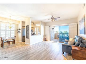 Bright living room with patio access, hardwood floors, and a comfortable couch at 14950 W Mountain View Blvd # 2301, Surprise, AZ 85374