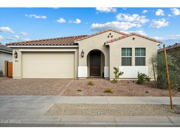 One-story home with neutral exterior, two-car garage, and landscaped front yard at 16780 W Cameron Dr, Surprise, AZ 85388