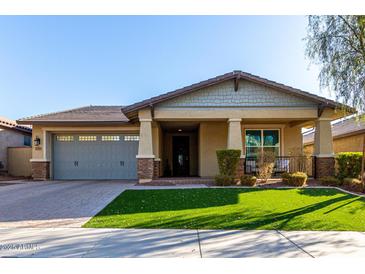 Single-story home with gray garage doors and a landscaped lawn at 2707 N Acacia Way, Buckeye, AZ 85396