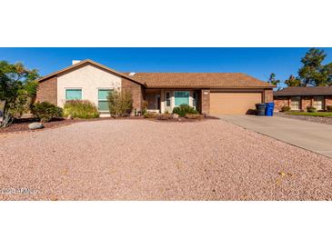 Single-story home with a two-car garage and well-maintained landscaping at 2728 E Encanto Cir, Mesa, AZ 85213