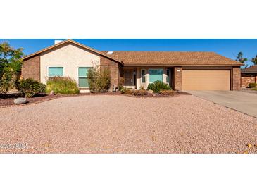 Brick ranch house with two-car garage and landscaped yard at 2728 E Encanto Cir, Mesa, AZ 85213