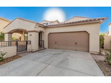 Tan two-story house with a brown door and two-car garage at 3040 N Point Ridge Rd, Buckeye, AZ 85396