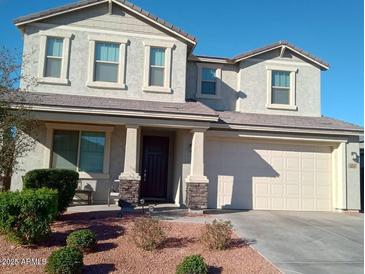 Two-story house with a beige exterior, brown door, and landscaping at 3094 N 195Th Dr, Buckeye, AZ 85396