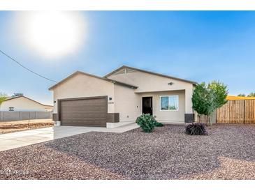 New construction home with a two-car garage and desert landscaping at 31828 N Ash St, Wittmann, AZ 85361