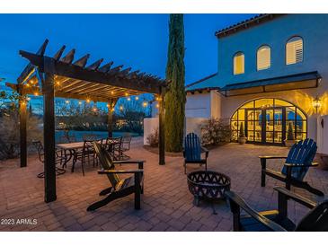 Outdoor patio with pergola, fire pit, and seating area at dusk at 32633 N 137Th St, Scottsdale, AZ 85262