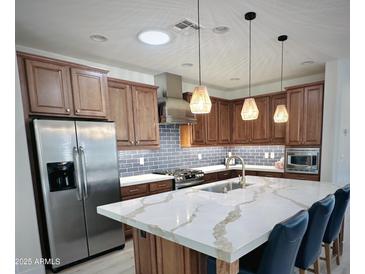 Modern kitchen features stainless steel appliances and a large island with quartz countertops at 6231 E Mark Way # 32, Cave Creek, AZ 85331