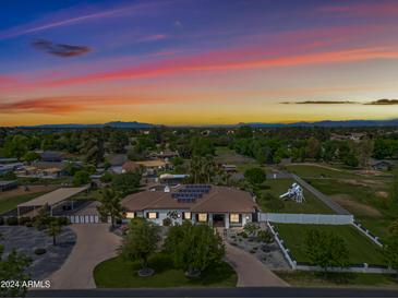 Aerial view of a house with solar panels, a large backyard, and mountain views at 715 S Cactus Wren St, Gilbert, AZ 85296