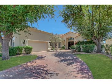 Stunning single-story home with lush landscaping and a large driveway at 7347 E Turquoise Ave, Scottsdale, AZ 85258