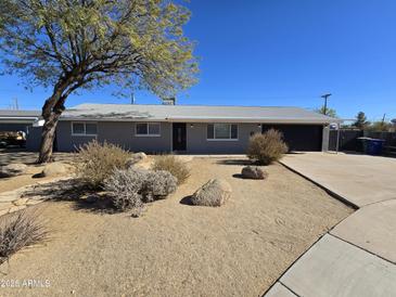 Ranch style home with gray exterior, landscaping, and a two-car garage at 813 S Doran Cir, Mesa, AZ 85204