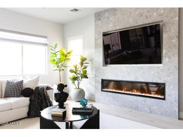 Living room with linear fireplace, built-in media niche and large windows at 10018 E Hillside Dr, Scottsdale, AZ 85255